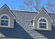 Residential roof detail around two dormer windows.
